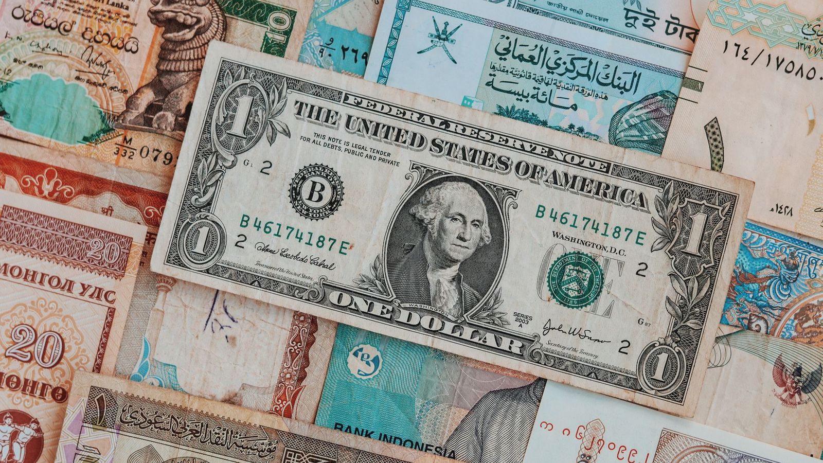 Des billets de plusieurs pays posés côte à côte, vus de dessus