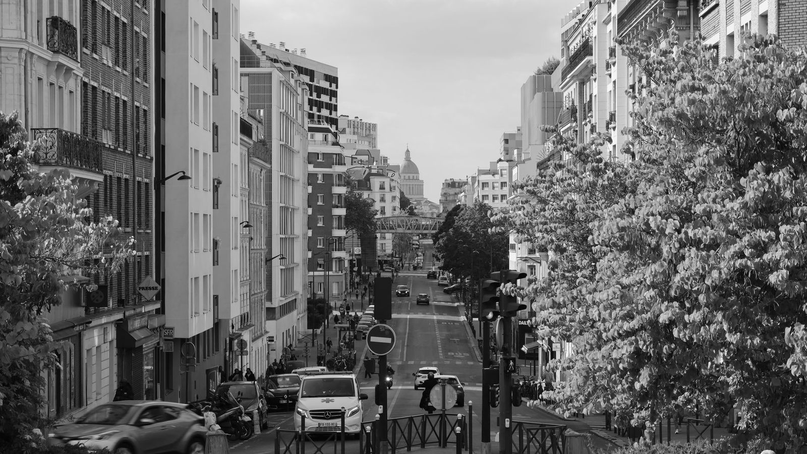 Une rue de Paris en noir et blanc, un dôme au fond