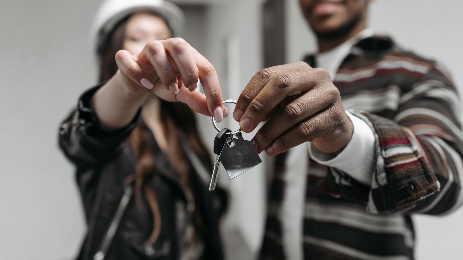 Deux mains tenant ensemble les clés d'un logement