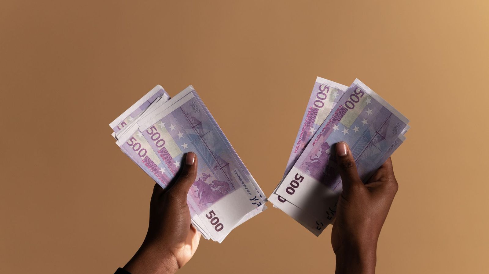 Des mains tenant des billets de 500 euros