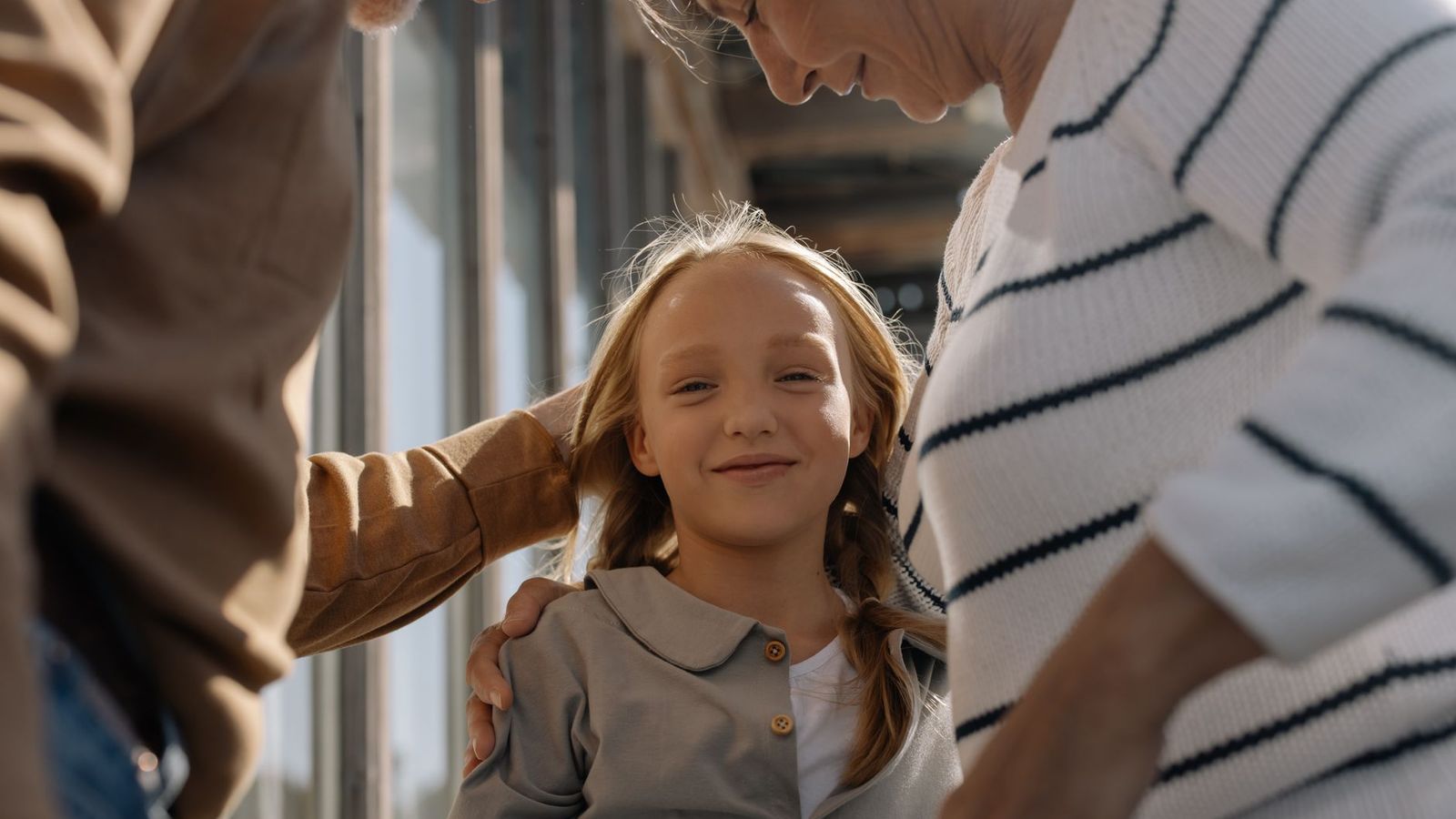 Une petite fille dans les bras de ses grands-parents