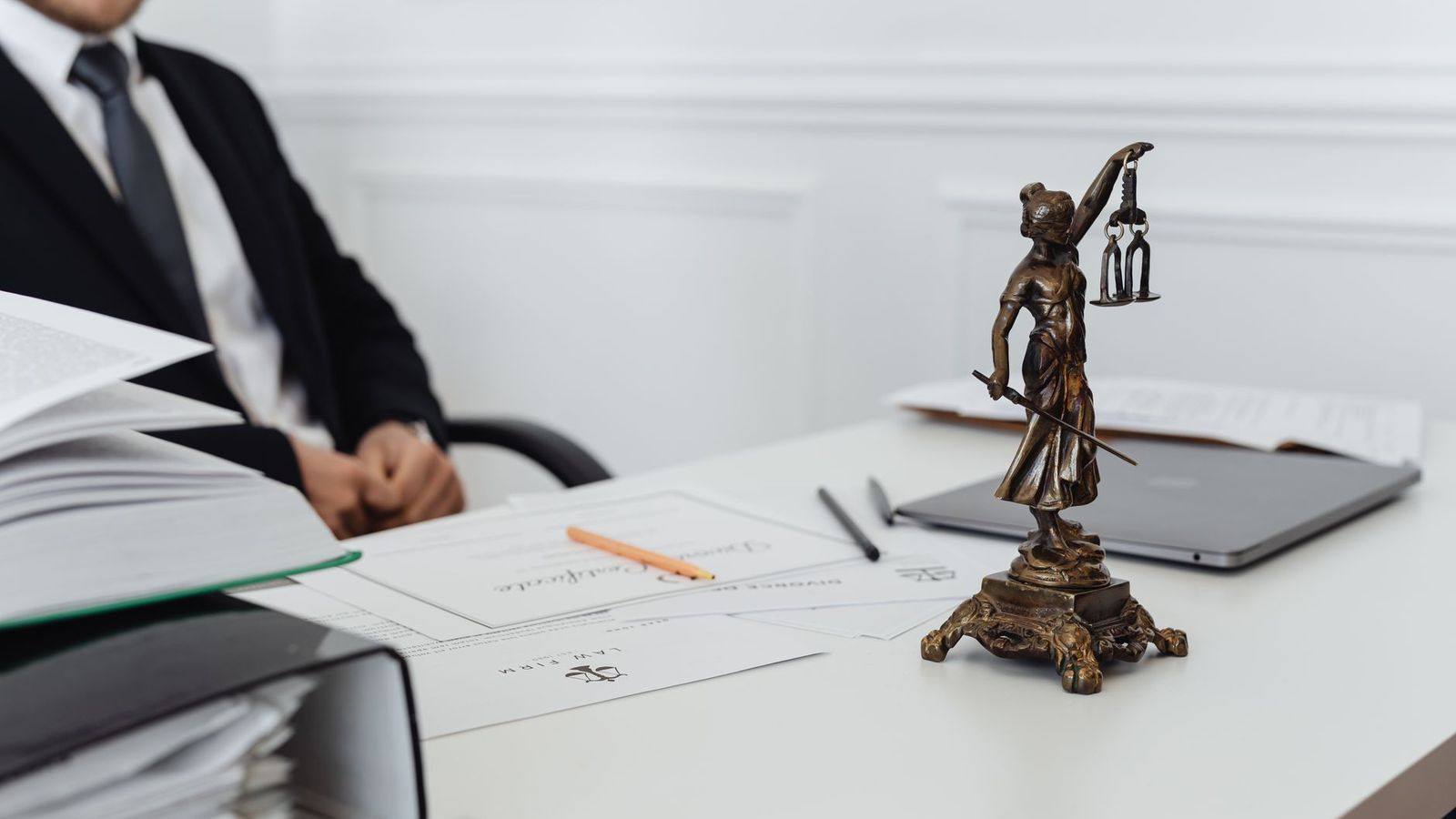 Un poste de travail de juriste : une statue de la justice, des documents et un ordinateur